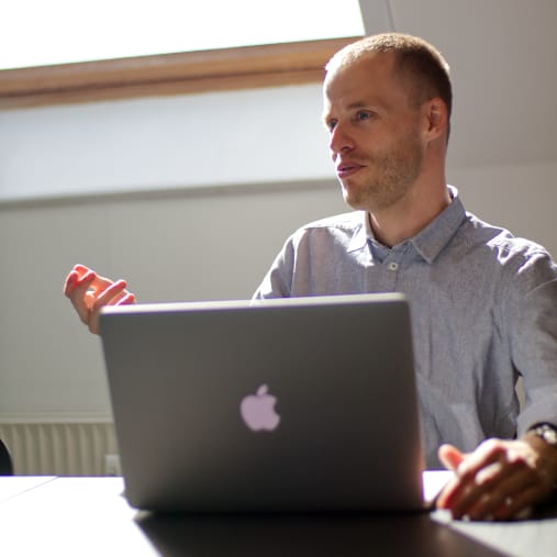 mand med macbook holder mĂžde